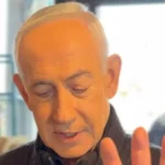 Benjamin Netanyahu holding coffee while addressing viral death rumors in 2026 video.